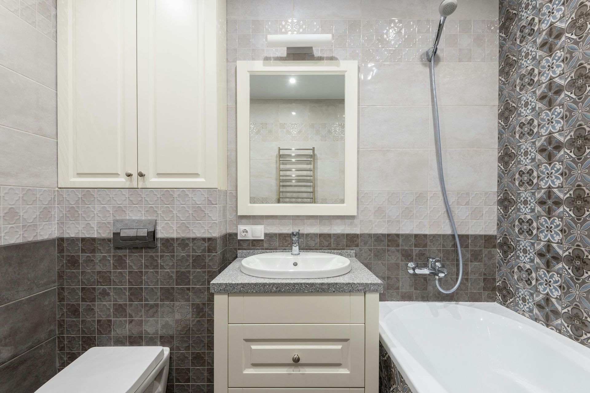 Cream bathroom vanity with a stone top, mirror and tiled surround