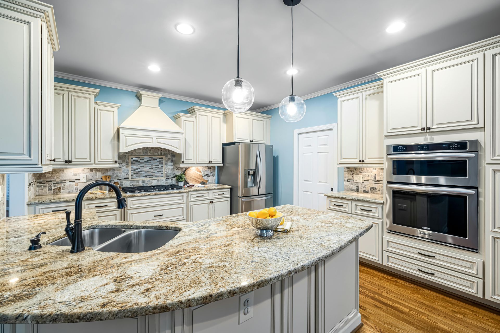 Traditional cream kitchen cabinets with a granite island and stainless appliances